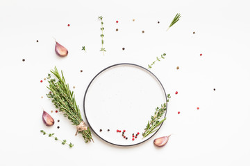 Empty plate with greens herbs and spices around