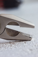 metal pliers head closeup on blurred background. hand tool close up. copy space. vertical