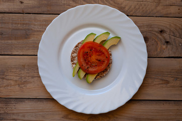 sandwich on a plate with avocado and tomatoes