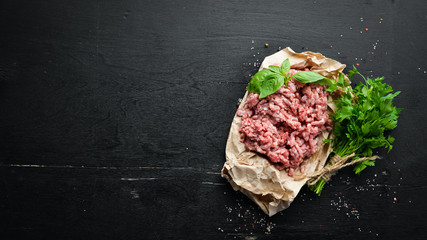Minced meat on a black background. Top view. Free space for your text.
