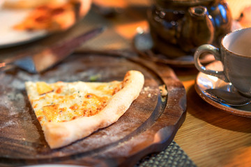 Fresh pizza with tomatoes and cheese on wooden board