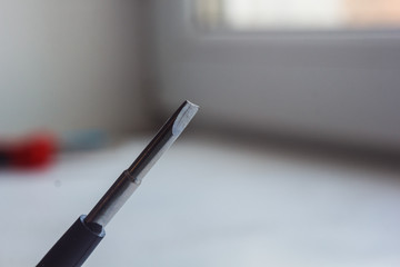 Fototapeta premium head of a metal flat screwdriver close-up on a blurred background. hand tool close up. copy space