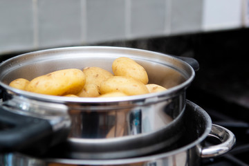 cooked jersey royal potatoes draining in a suacepan