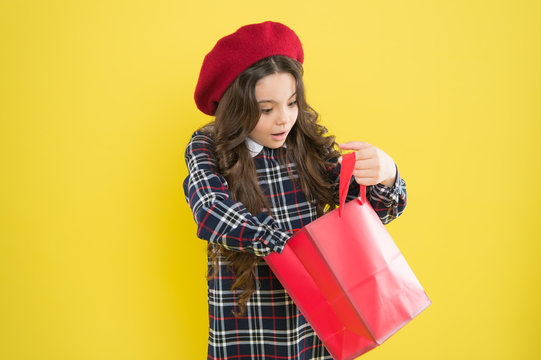 Just A Minute Of Surprise. Little Girl Looking For Surprise Gift On Yellow Background. Small Child Holding Shopping Bag With Surprise. Adorable Shopper With Surprise Emotion On Face