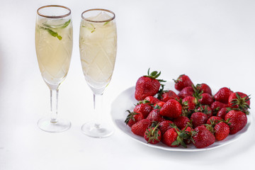 two glasses of champagne and a plate of strawberries