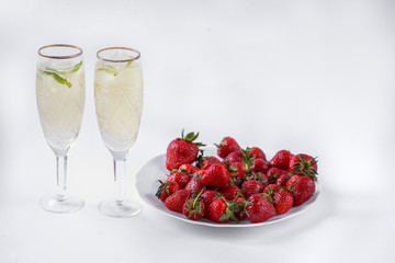 two glasses of champagne and a plate of strawberries