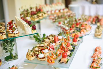 Catering. Off-site food. Buffet table with various canapes, sandwiches, hamburgers and snacks.