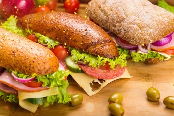 Fresh tasty sandwiches on wooden background
