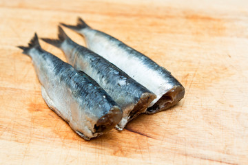 close up of sardines on a wooden chopping board