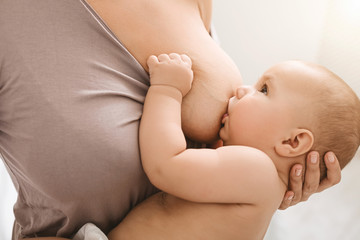 Mother breast feeding and hugging her baby