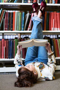 Female student reading book in a public library