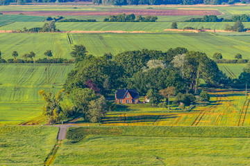 Naklejka premium View over the Elbauen in Lower Saxony, Germany. You see a landscape with fields, meadows and trees as well as a house, which is typical for this region.