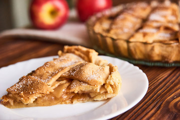 Apple autumn pie with cut slice on the plate on wooden background