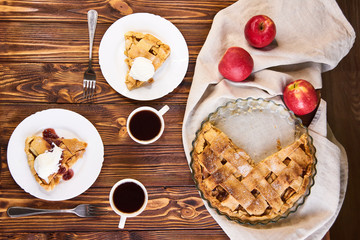 Tasty homemade apple pie, slice with ice cream. Apples. Plate. Woolen blanket Wooden background Top view