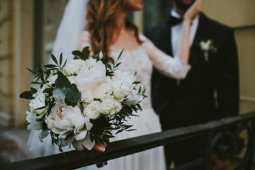 bride and groom behind bouquet