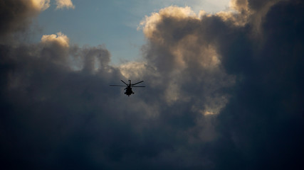 Flying helicopter in the storm sky