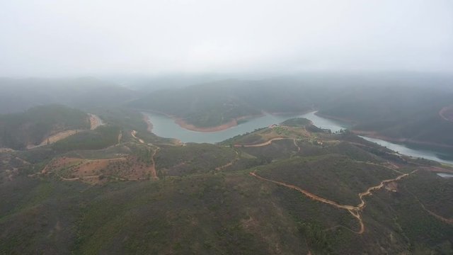 Aerial. Flying drone in fog and clouds over the hills in Monchique Portugal.