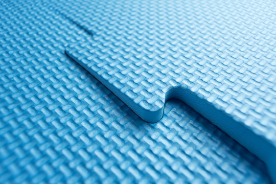 Heavy duty blue foam interlocking jigsaw floor tiles on an incline / slant. Potential use as a background or trip hazard concept.