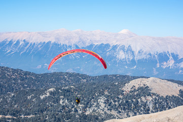 Paraglider flying over mountains