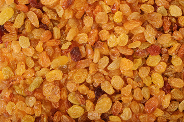 Yellow sweet raisins as abstract delicious background texture. Dried fruits. Top view.