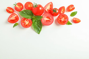 Fototapeta premium Flat lay composition with fresh cherry tomatoes and basil on white background, space for text. Ripe vegetables