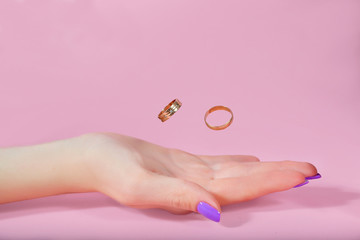 rings in hand on a pink background in flight. newlyweds wedding