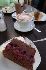 Kirsch Schokotorte gestürzt auf Teller mit Kakao im Hintergrund