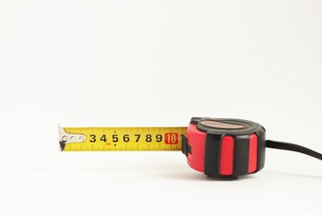 repair and construction concept. red with black construction roulette isolated on a white background close up. front view with copy space for text.