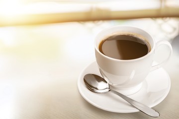 Coffee cup and spoon on wooden background