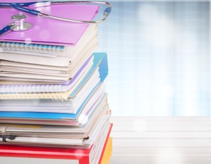 Stethoscope with a stack of reference books isolated