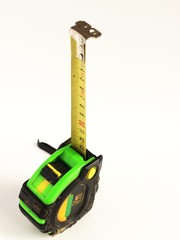 repair and construction concept. green with black construction roulette isolated on a white background close up. front view with copy space for text.
