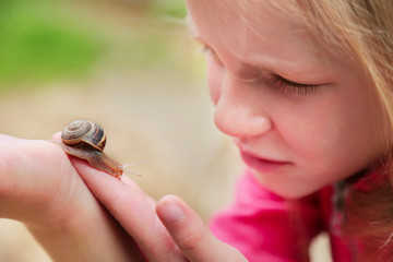 little girl holding snails on her hand