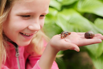 little girl holding snails on her hand