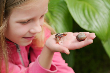 little girl holding snails on her hand