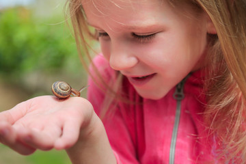 little girl holding snails on her hand