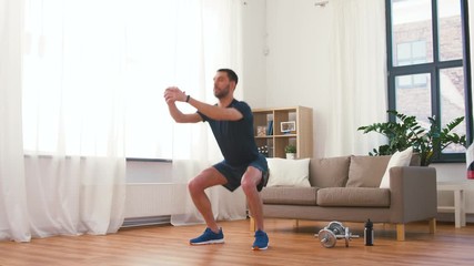 fitness, sport and healthy lifestyle concept - man exercising and doing squats at home - Powered by Adobe