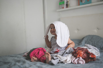 big pile of clean clothes and baby playing