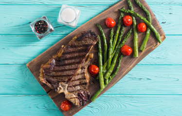 Grilled T-bone steak with asparagus and cherry tomatoes