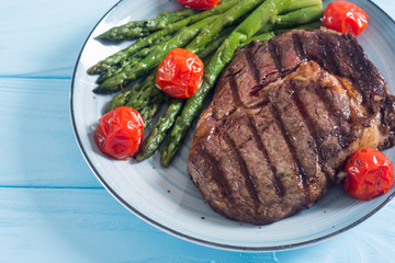 Grilled beef steak ribeye with cherry tomatoes and asparagus