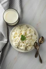 Cottage cheese isoalted on light, marble background. Dairy products, calcium and protein. Healthy breakfast. Vertical image.