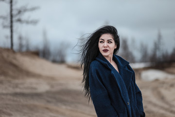 Young woman walking in a cold sandy desert