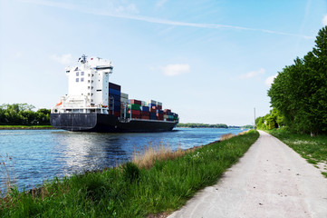Nord-Ostsee-Kanal in Schleswig-Holstein, Containerschiff mit Radwanderweg in Rendsburg
