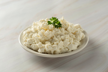 Cottage cheese isoalted on light, marble background. Dairy products, calcium and protein. Healthy breakfast.
