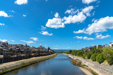 Naklejka na ściany i meble Beautiful scenery of Kamo River or Kamogawa in Kyoto City, Japan. Ancient wooden houses on the riverbanks are transformed into restaurants, a popular walking spots for residents and tourist.