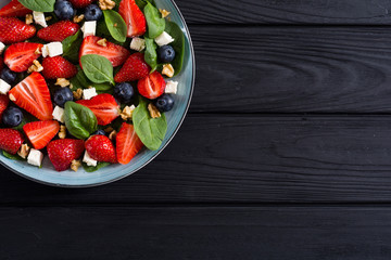 Summer Strawberry salad with spinach , cheese , nuts and blueberry