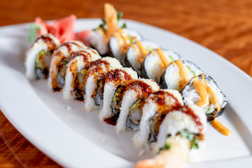 Tempura Shrimp Sushi Rolls with Salmon Avocado Tuna and Spicy Mayo Up-Close on a White Plate