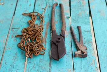 Background from old rusty bolts, screws, nuts, screws, brackets, various metal details. Rusty set of hand tools. blue wooden background. Vintage tools. Artisan work concept.