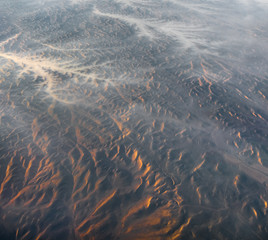 Aerial View from an Airplane. Flying above Beautiful Land at Sunrise.