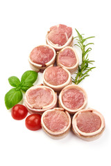 Raw meat medallions wrapped in bacon, top view, isolated on white background