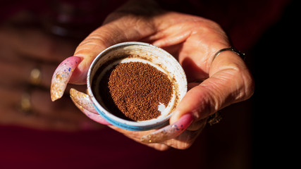 close-up oa a womans hand holding a cup of tobacco seed